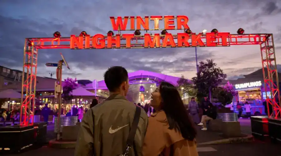 A couple approach the entry to Melbourne’s Queen Victoria Winter Night Market.
