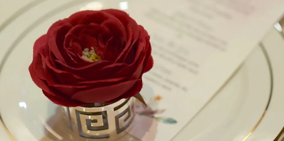 A red rose on saucer.