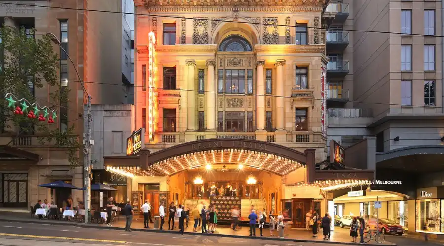 Regent Theatre Melbourne lit up at dusk with visitors arriving for a show.
